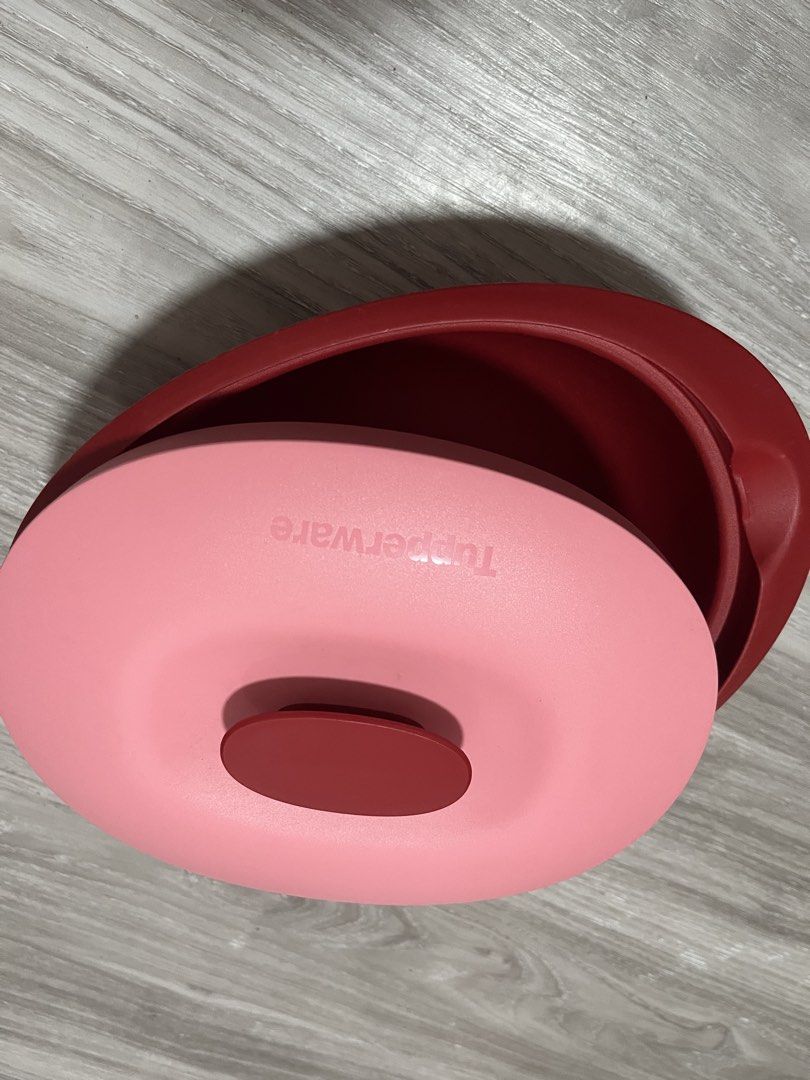 Tupperware Red Bowl with Pink Lid (Category: Other Kitchenware & Tableware) located in Quezon City. Submitted by larenaxoxo (Listing ID 1448272109, Image 2). Description: - Red Tupperware bowl with a vibrant pink lid. - Perfect for storing leftovers or mixing ingredients. - Deep bowl design with a wide opening for easy access. - Lid fits snugly to keep contents fresh. - Made from durable, high-quality plastic. - Features the iconic Tupperware log