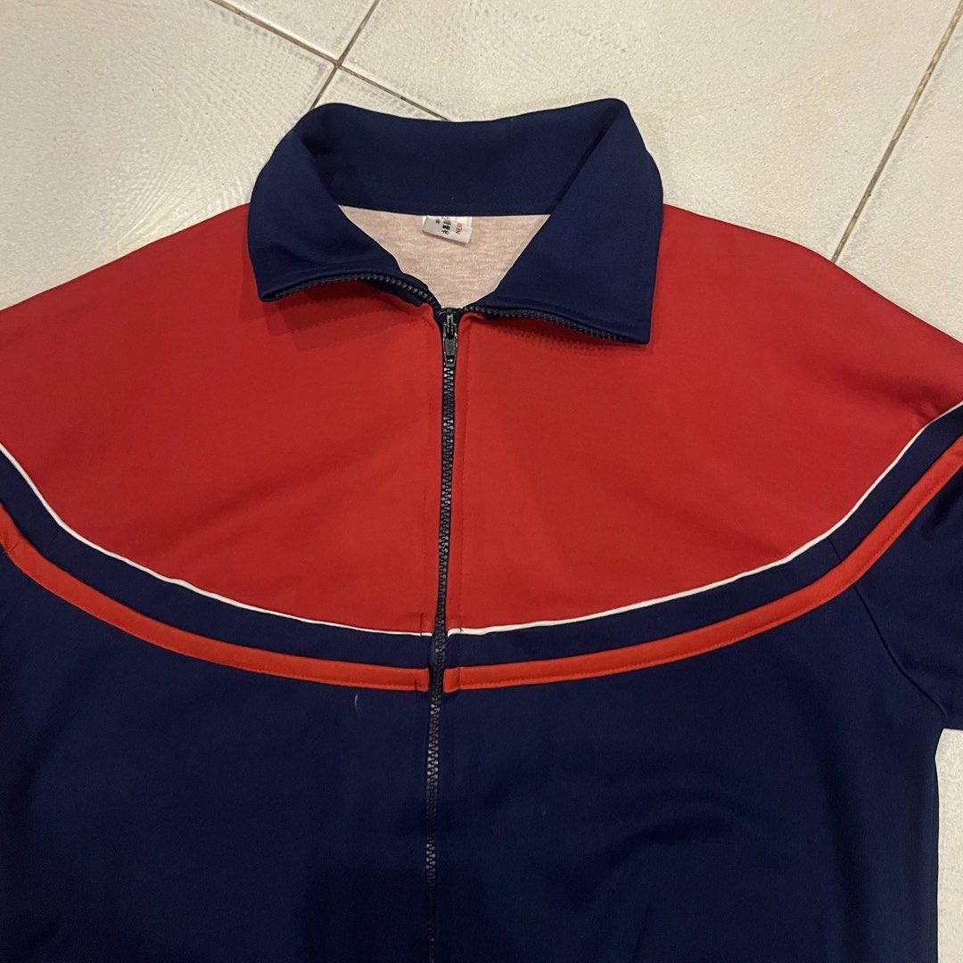 Vintage Red and Navy Blue Track Jacket (Category: Coats, Jackets and Outerwear) located in Santa Rosa. Submitted by bats_ (Listing ID 1448227181, Image 2). Description: - Classic track jacket style - Eye-catching color-block design: Red on top, navy blue on bottom - White stripe detail across the chest - Full zip closure for easy wear - Comfortable collar neckline - Versatile for casual outfits or layering.
