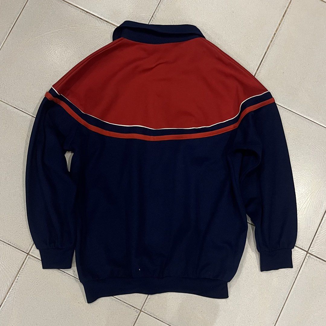 Vintage Red and Navy Blue Track Jacket (Category: Coats, Jackets and Outerwear) located in Santa Rosa. Submitted by bats_ (Listing ID 1448227181, Image 3). Description: - Classic track jacket style - Eye-catching color-block design: Red on top, navy blue on bottom - White stripe detail across the chest - Full zip closure for easy wear - Comfortable collar neckline - Versatile for casual outfits or layering.