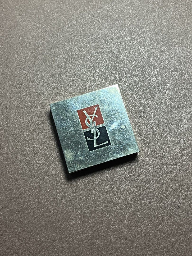 Yves Saint Laurent YSL Vintage Compact Mirror Case (Category: Makeup) located in Manila. Submitted by carmiscloset (Listing ID 1448262796, Image 1). Description: - Vintage YSL compact case - Silver tone with iconic YSL logo - Mirror inside is intact - Some signs of wear on exterior metal casing - Closes securely - Classic makeup accessory.
