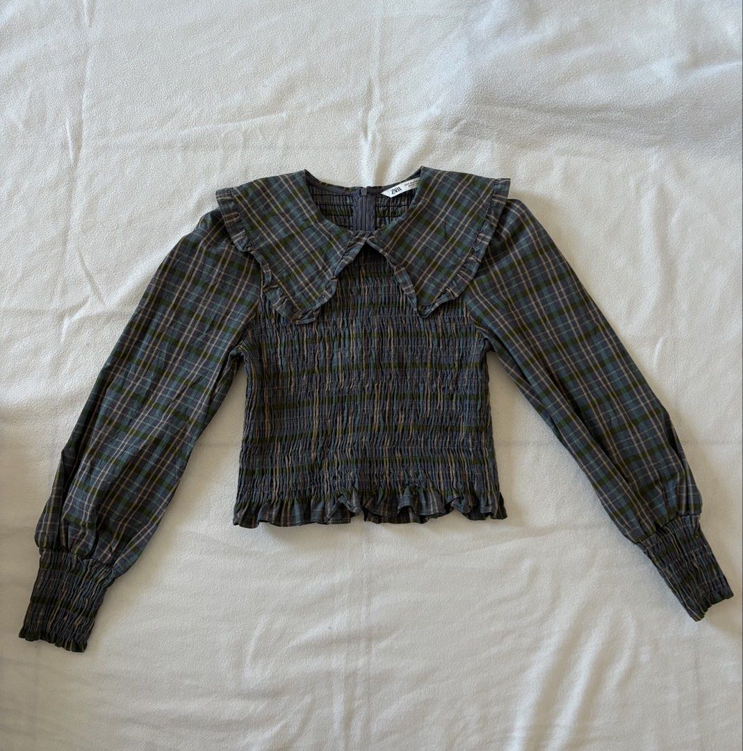 Zara Plaid Smocked Collared Long Sleeve Top (Category: Blouses) located in Taguig. Submitted by cftbncs (Listing ID 1448078203, Image 1). Description: - Zara grey and green plaid long sleeve top - Smocked bodice - Ruffled collar - Zipper closure at the back - Balloon sleeves with elastic cuffs - Pairs well with high-waisted jeans or skirts.