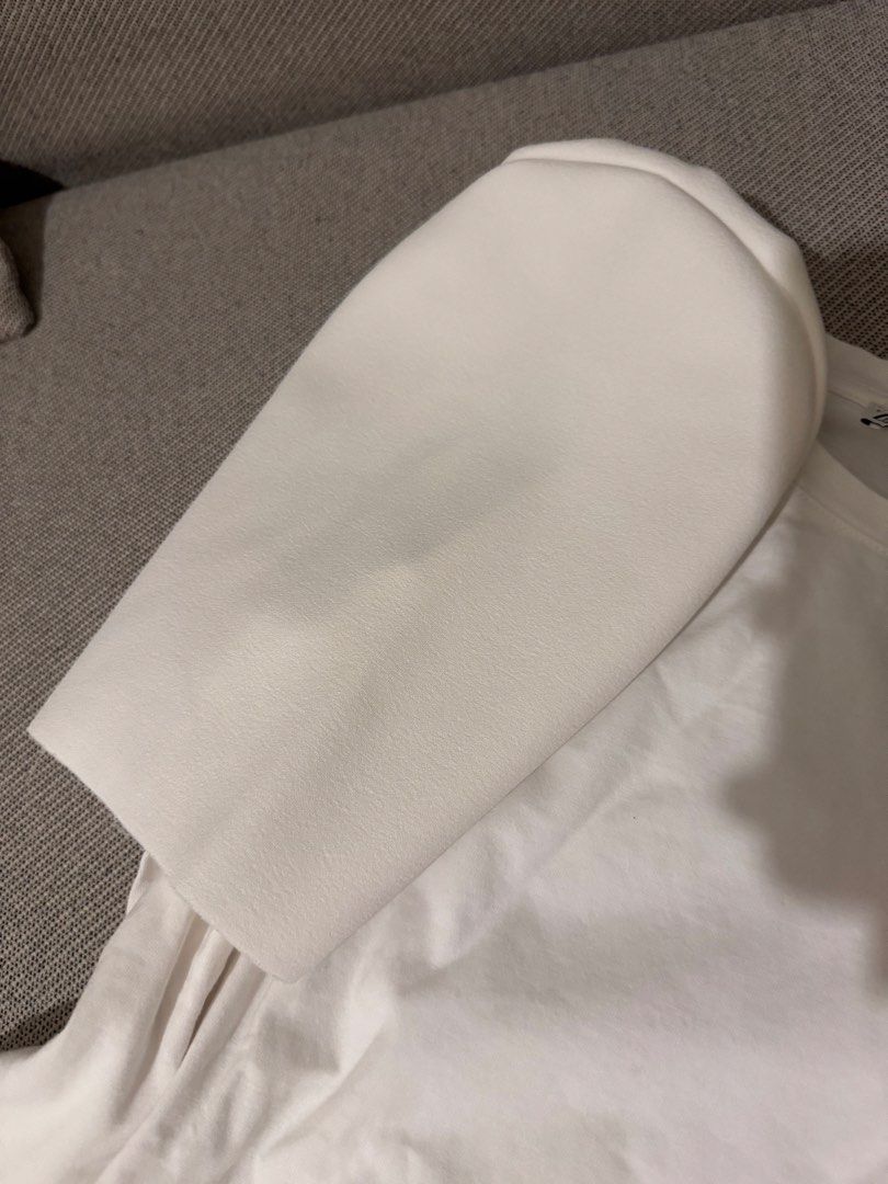 ZARA White T-shirt with Statement Puffy Sleeves (Category: Shirts) located in Mandaluyong City. Submitted by cartmyitems (Listing ID 1448190908, Image 2). Description: - Brand: ZARA - Color: White - Style: T-shirt with unique structured puffy sleeves - Sleeve Texture: Smooth, almost leather-like - Body Material: Soft cotton - Size: S - Key Feature: Statement piece to elevate casual outfits.