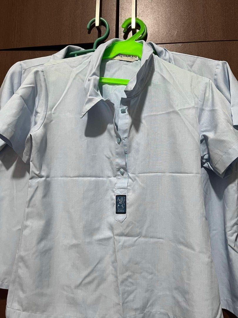ADAMSON SHS UNIFORM (Category: Tshirts & Polo Shirts ) located in Manila. Submitted by ezxraax (Listing ID 1448433986, Image 1). Description: - Light blue short-sleeved shirt - Classic collar and button-up front - Small black tag with 'ADU' logo on the chest - Ideal for daily wear or school uniform.