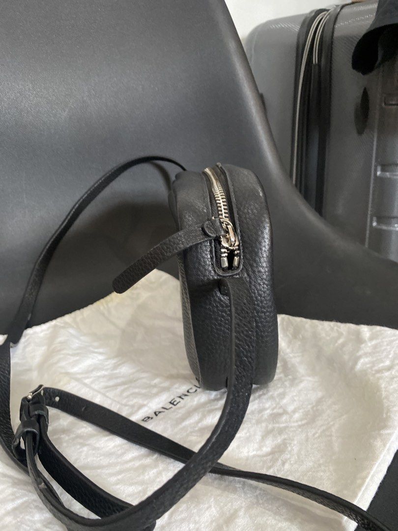 Balenciaga Black Leather Camera Bag (Category: Luxury Bags & Wallets) located in Las Pinas. Submitted by harper_preloved (Listing ID 1448394519, Image 2). Description: - Japan Flea market finds - Authentic Balenciaga black leather camera bag - Features a pebbled leather texture - Accented with silver hardware and zipper - Adjustable strap for comfortable wear - Includes original dust bag - Ideal for everyday essentials and style.