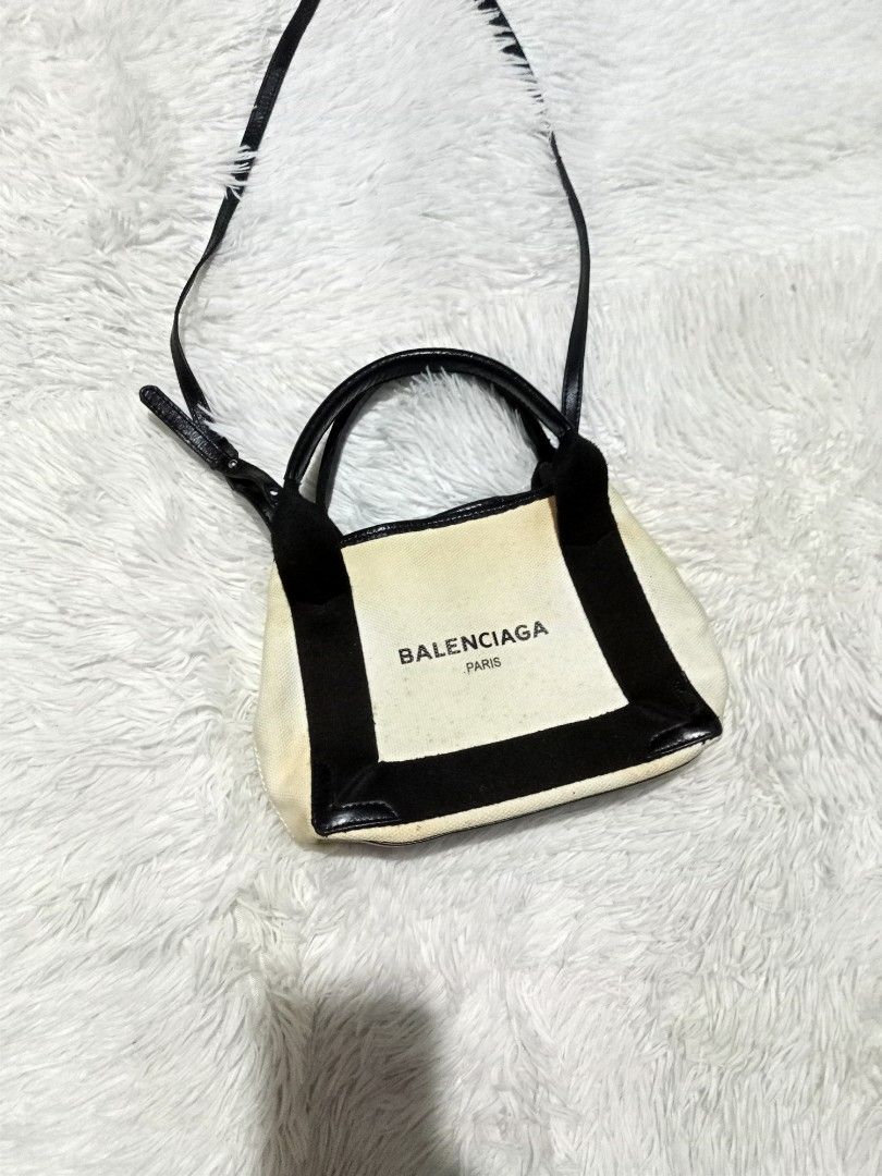 Balenciaga Paris Canvas & Leather Mini Handbag (Category: Luxury Bags & Wallets) located in Polomolok. Submitted by aldrex_18 (Listing ID 1448346469, Image 2). Description: - Balenciaga Paris mini bag - Canvas body with black leather trim and handles - Includes adjustable shoulder strap - Black interior - Shows some signs of wear on leather and canvas - Ideal for carrying essentials.