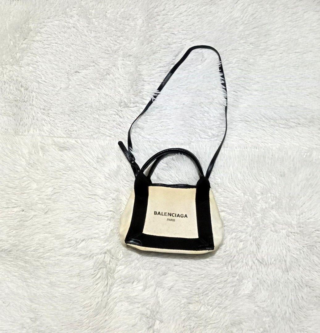 Balenciaga Paris Canvas & Leather Mini Handbag (Category: Luxury Bags & Wallets) located in Polomolok. Submitted by aldrex_18 (Listing ID 1448346469, Image 1). Description: - Balenciaga Paris mini bag - Canvas body with black leather trim and handles - Includes adjustable shoulder strap - Black interior - Shows some signs of wear on leather and canvas - Ideal for carrying essentials.