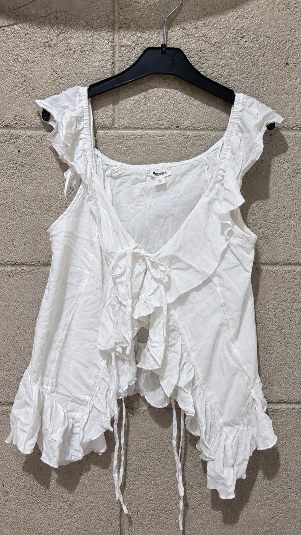 Bershka White Ruffle Tie Front Crop Top (Category: Sleeveless) located in Manila. Submitted by shechlow (Listing ID 1448482699, Image 1). Description: Brand New Bershka Ruffle Top 🤍 ✨ Never worn Size: Small Original from Bershka Megamall 💸 ₱650 DM to mine ✨.