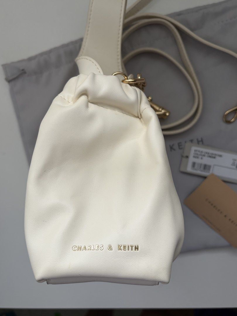 Charles & Keith - Ally Ruched Dumpling Bag (Cream) (Category: Shoulder Bags) located in Quezon City. Submitted by nikerlle (Listing ID 1448325453, Image 3). Description: - 8/10 condition, almost like new - Ruched design, dumpling bag. I think their inspo here is Polene Neuf - Comes with original CK dust bag and tags - Includes a detachable long strap, chain handle (not tarnished yet) - Guaranteed authentic, bought this from Glorietta no more pape