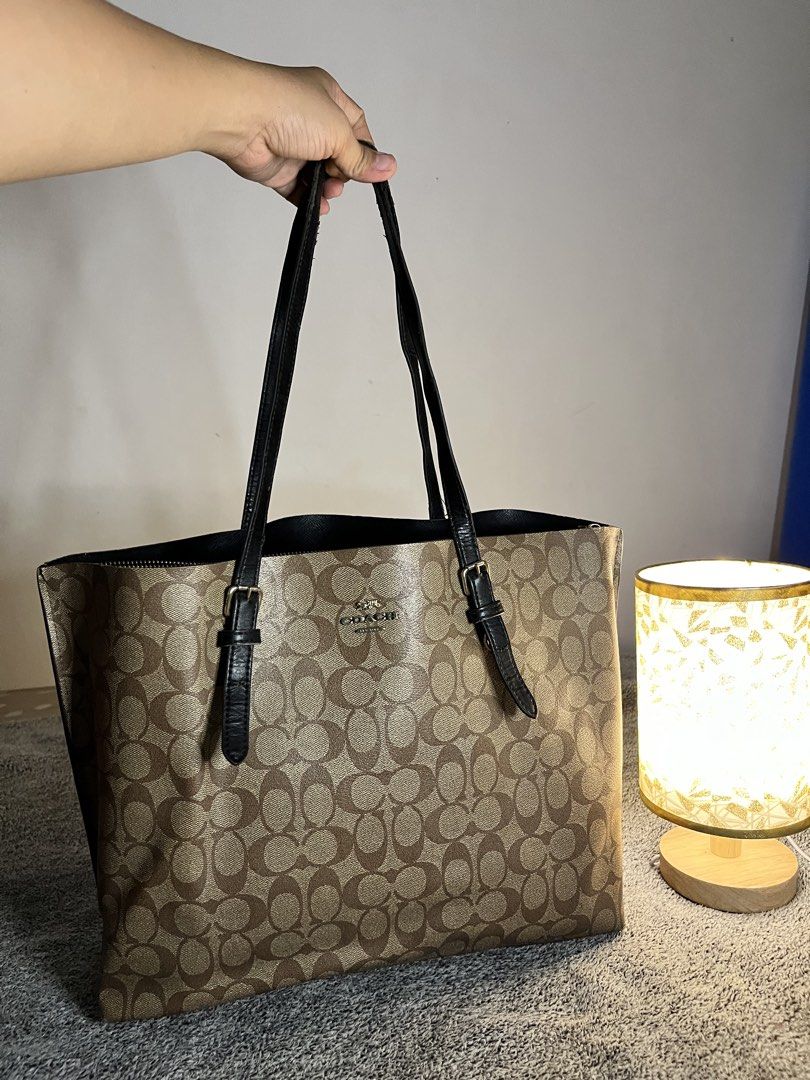 Coach Monogram Canvas Tote Bag (Category: Luxury Bags & Wallets) located in Malaybalay. Submitted by yanshoppe (Listing ID 1448433731, Image 2). Description: - Classic Coach tote bag - Brown monogram canvas with black leather trim - Spacious interior, ideal for everyday or travel - Secure top zip closure - Comfortable double shoulder straps - A versatile bag for all your essentials.