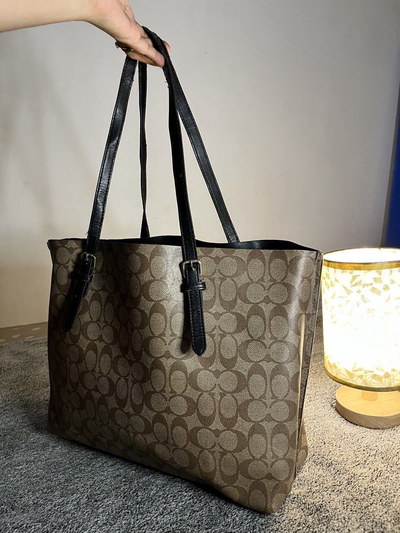 Coach Monogram Canvas Tote Bag (Category: Luxury Bags & Wallets) located in Malaybalay. Submitted by yanshoppe (Listing ID 1448433731, Image 3). Description: - Classic Coach tote bag - Brown monogram canvas with black leather trim - Spacious interior, ideal for everyday or travel - Secure top zip closure - Comfortable double shoulder straps - A versatile bag for all your essentials.
