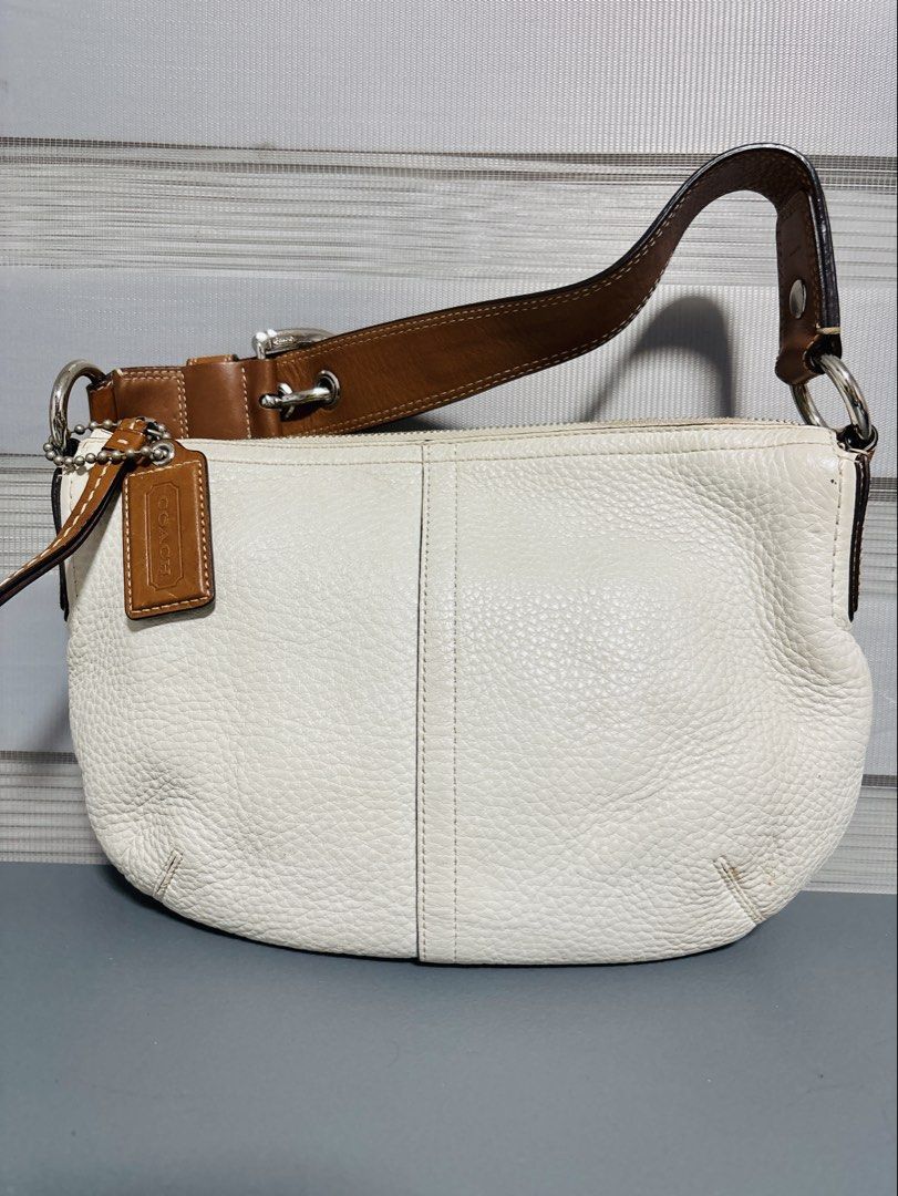 Coach White Leather Hobo Shoulder Bag (Category: Luxury Bags & Wallets) located in Manila. Submitted by mercy14_moon (Listing ID 1448337786, Image 1). Description: - Authentic Coach hobo bag - White pebbled leather with brown leather strap and trim - Silver hardware accents - Secure zipper closure - Spacious interior, ideal for everyday essentials - Includes original Coach leather hangtag.