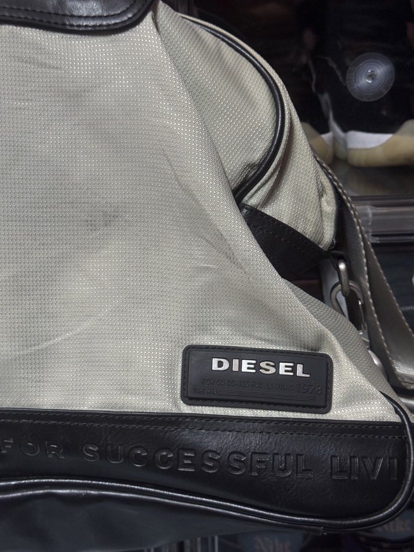 Diesel Canvas and Leather Duffle Bag (Category: Luxury Bags & Wallets) located in Makati City. Submitted by vinsanity41546 (Listing ID 1448446117, Image 2). Description: - Brand: Diesel - Color: Light grey canvas with dark brown leather trim - Design detail: "For Successful Living" embossed on leather - Straps: Top handles and a detachable shoulder strap - Interior: Spacious, great for everyday essentials - Condition: Excellent for daily use.