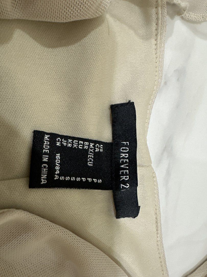 Forever 21 Beige Mesh Ruched Puff Sleeve Top Size S (Category: Blouses) located in Kuala Lumpur. Submitted by princess7766 (Listing ID 1448454914, Image 2). Description: - Beige mesh top from Forever 21 - Ruched detailing on the front - Puff sleeves - Square neckline with ruffled trim - Side zipper closure - Size S - Perfect for dressing up or down.