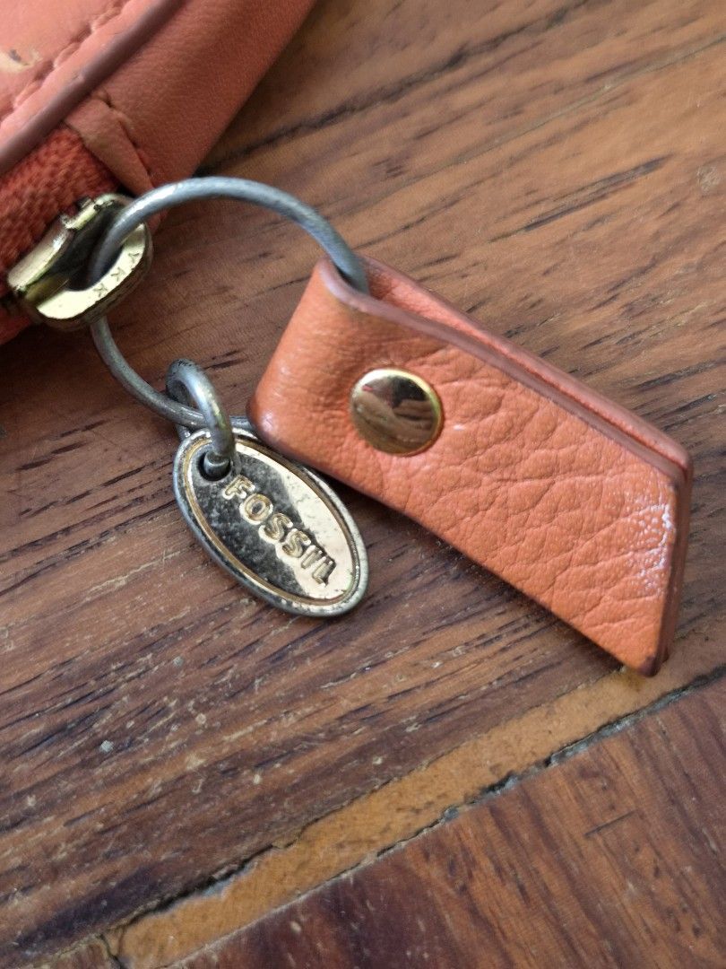 Fossil Heart Shaped Coin Pouch Orange Leather (Category: Purses & Pouches) located in Santo Tomas. Submitted by anacristin90526 (Listing ID 1448306942, Image 2). Description: - Cute heart-shaped coin pouch - Brand: Fossil - Color: Orange - Material: Leather - Design: Arrow detail - Closure: Zipper - Perfect for coins and small essentials.