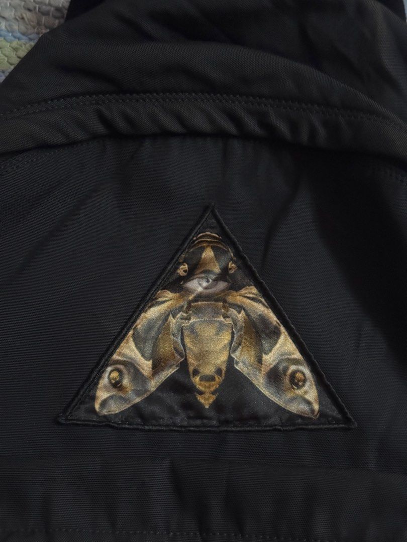 Givenchy Black Nylon Backpack with Moth Emblem (Category: Luxury Bags & Wallets) located in Makati City. Submitted by vinsanity41546 (Listing ID 1448445368, Image 3). Description: - Authentic Givenchy black nylon backpack - Features iconic moth emblem on the front - "REAL EYES. REALIZE. REAL LIES." text detail - Adjustable straps for comfortable wear - Stylish leather accents - Ideal for everyday use and travel.