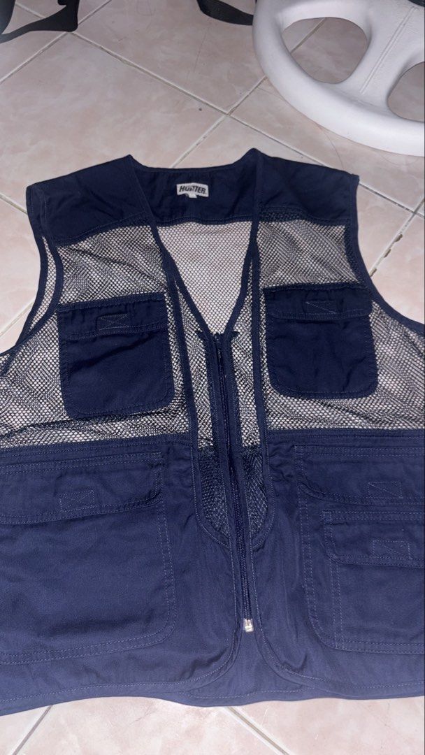 Hunter Navy Mesh Utility Vest (Category: Vests) located in Taguig. Submitted by elymalbueso (Listing ID 1448283105, Image 1). Description: - Hunter navy blue utility vest - Features a breathable mesh back - Multiple chest pockets for easy access - Secure zipper closure - Ideal for outdoor adventures or as a stylish layering piece - Ample storage with numerous pockets.