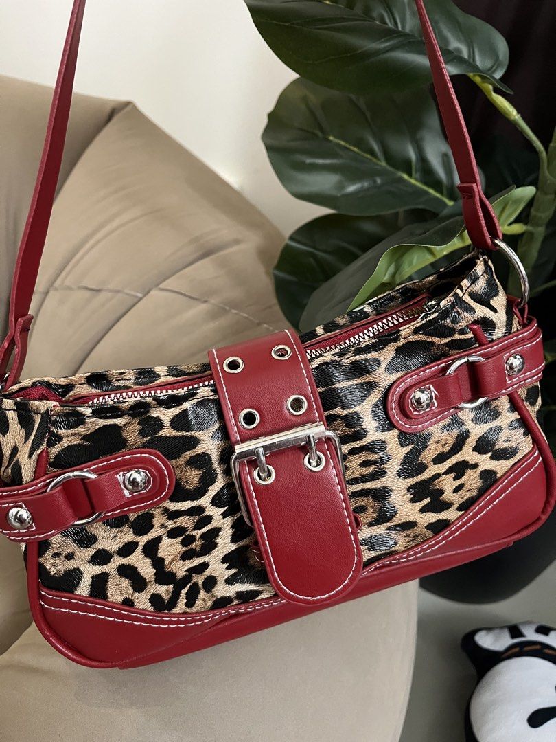 Leopard Print & Red Faux Leather Shoulder Bag (Category: Shoulder Bags) located in Trece Martires City. Submitted by miaaamic (Listing ID 1448299245, Image 2). Description: - Adorable leopard print shoulder bag - Stylish red trim and front buckle detail - Adjustable strap for comfortable wear - Secure zipper closure at the top - Ideal for carrying your daily essentials.
