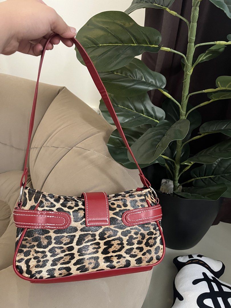 Leopard Print & Red Faux Leather Shoulder Bag (Category: Shoulder Bags) located in Trece Martires City. Submitted by miaaamic (Listing ID 1448299245, Image 3). Description: - Adorable leopard print shoulder bag - Stylish red trim and front buckle detail - Adjustable strap for comfortable wear - Secure zipper closure at the top - Ideal for carrying your daily essentials.