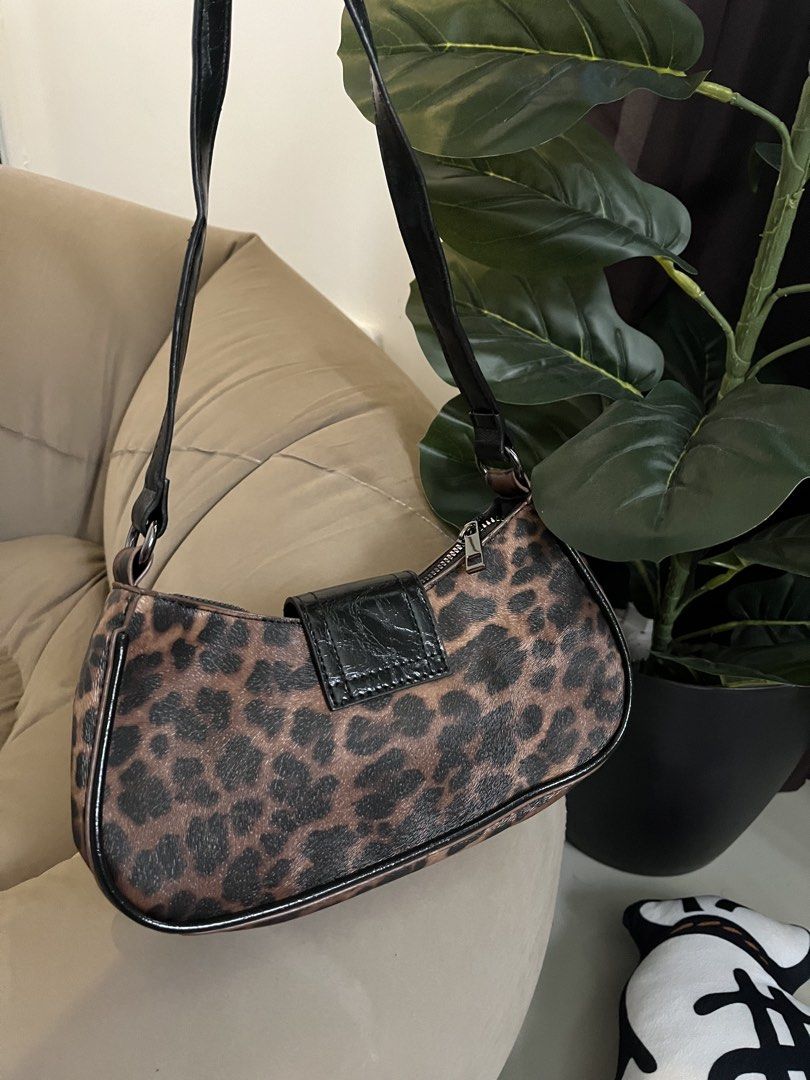 Leopard Print Shoulder Bag with Buckle Detail (Category: Shoulder Bags) located in Trece Martires City. Submitted by miaaamic (Listing ID 1448299477, Image 3). Description: - Adorable leopard print shoulder bag - Features a stylish black buckle on the front - Adjustable strap for comfortable wear - Secure zipper closure - Ideal for carrying your daily essentials - Adds a fun and trendy touch to any outfit.