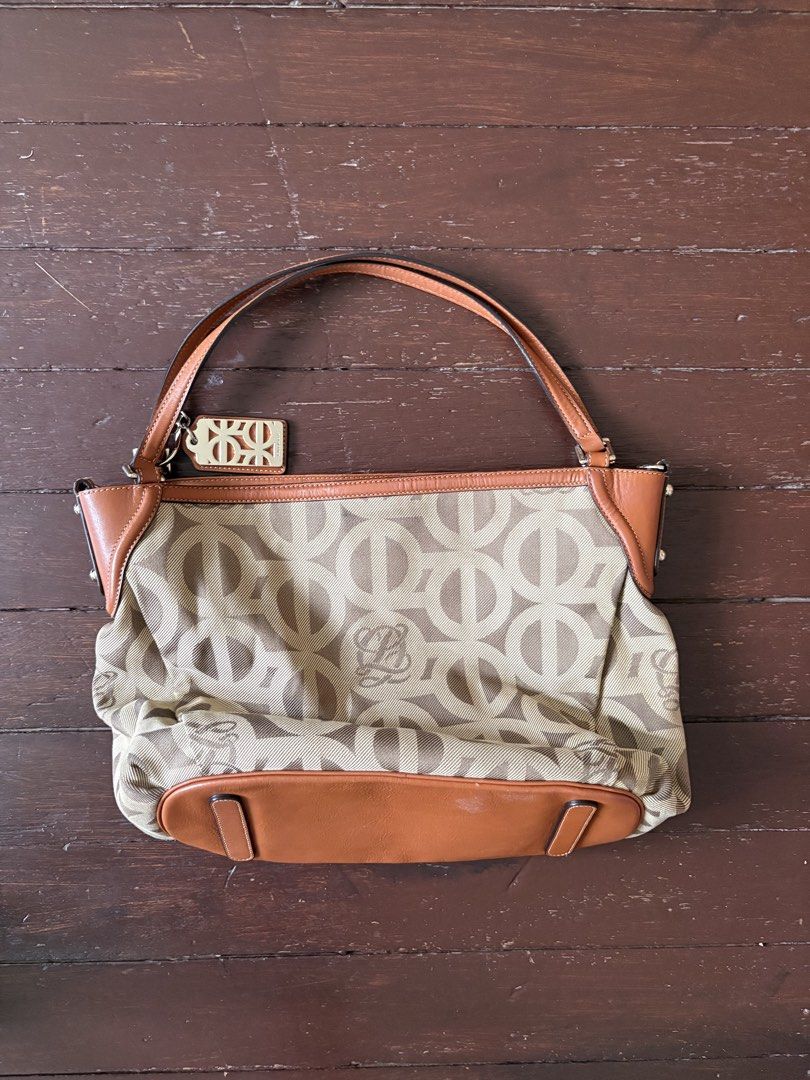 LQ Monogram Canvas Leather Shoulder Bag (Category: Luxury Bags & Wallets) located in Makati City. Submitted by goodfindsonly (Listing ID 1448347536, Image 1). Description: - LQ Anagram shoulder bag - Beige canvas with brown leather trim - Features iconic Loewe anagram pattern - Comes with a detachable strap - Adorned with a metal logo tag - Ideal for everyday carry.