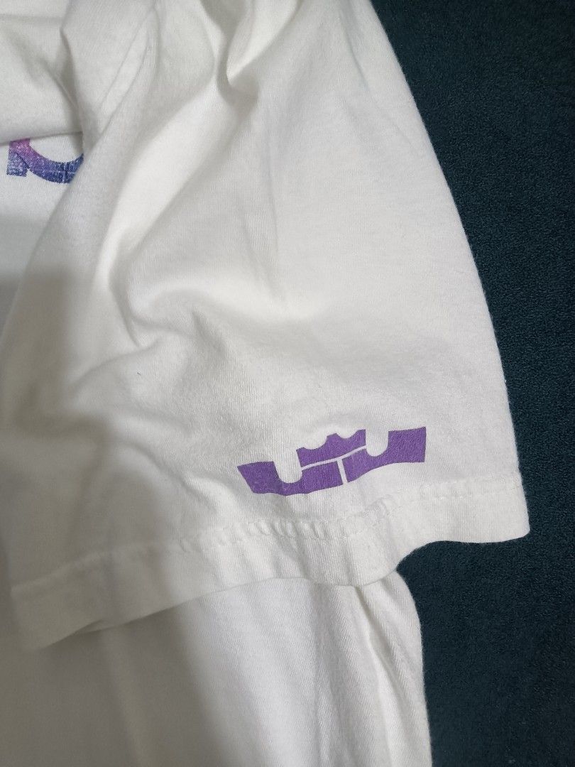 Nike (Category: Tshirts & Polo Shirts) located in Kuala Lumpur. Submitted by lubuk_xl (Listing ID 1448418776, Image 3). Description: - Brand: Nike - Color: White - Size: XL - Design: 'WITNESS' graphic with multi-colored fill and Nike swoosh - Sleeve Detail: Purple LeBron James crown logo - Condition: Good.