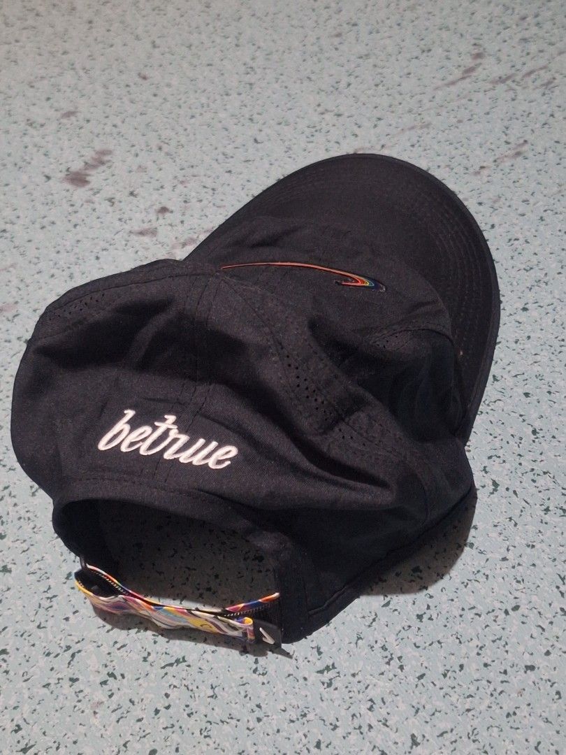 Nike Be True Featherlight Dri-Fit Cap Rainbow Swoosh (Category: Caps & Hats) located in Paranaque City. Submitted by boiwiz01 (Listing ID 1448391736, Image 2). Description: - Black Nike Dri-Fit Featherlight Cap - Features iconic rainbow swoosh logo - 'betrue' embroidery on the side - Inner band with a vibrant geometric pattern - Lightweight and breathable, ideal for running or everyday wear.