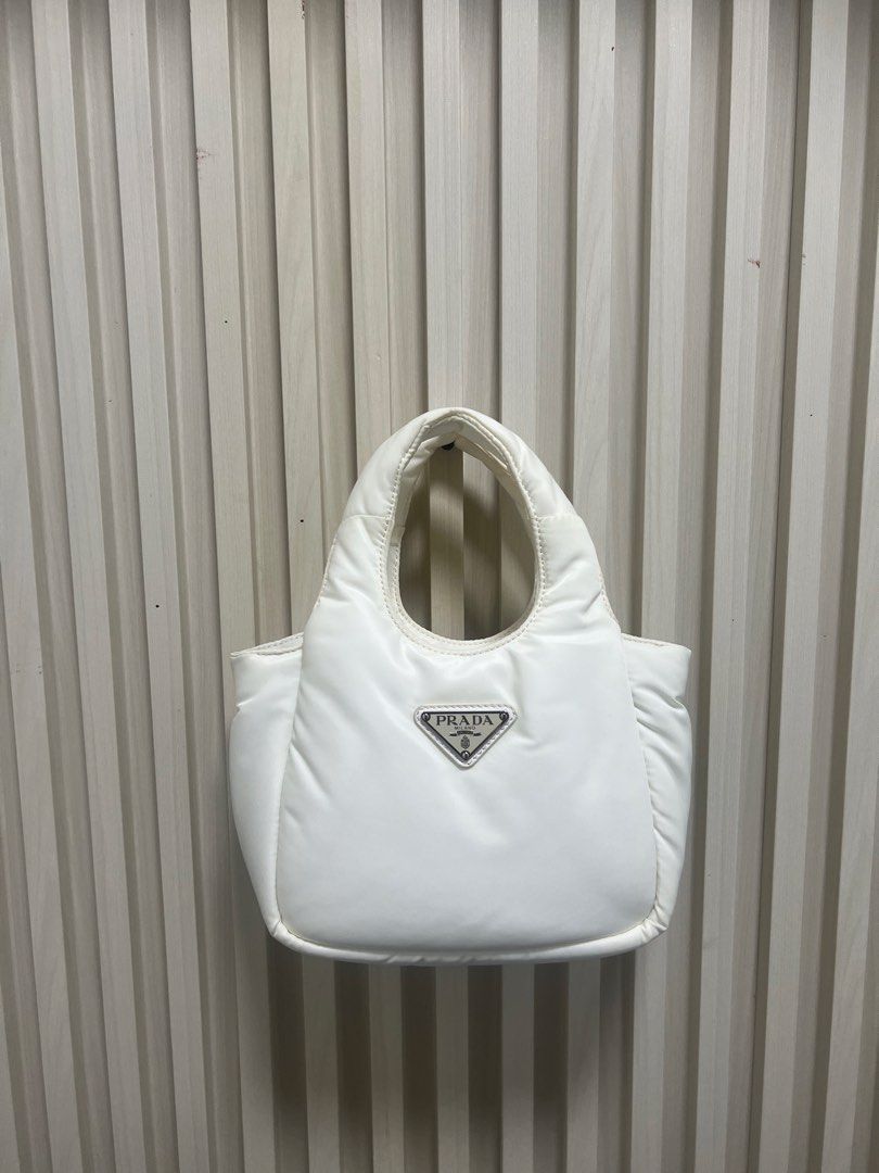 Prada White Nylon Puffer Tote Bag (Category: Luxury Bags & Wallets) located in Manila. Submitted by gailmg (Listing ID 1448364417, Image 2). Description: - NGA -Self Authenticated - White Prada Nylon Puffer Tote - Cute and puffy design - Features the iconic Prada triangle logo on the front - Ideal for everyday use - Spacious interior for your essentials - A stylish addition to any outfit.