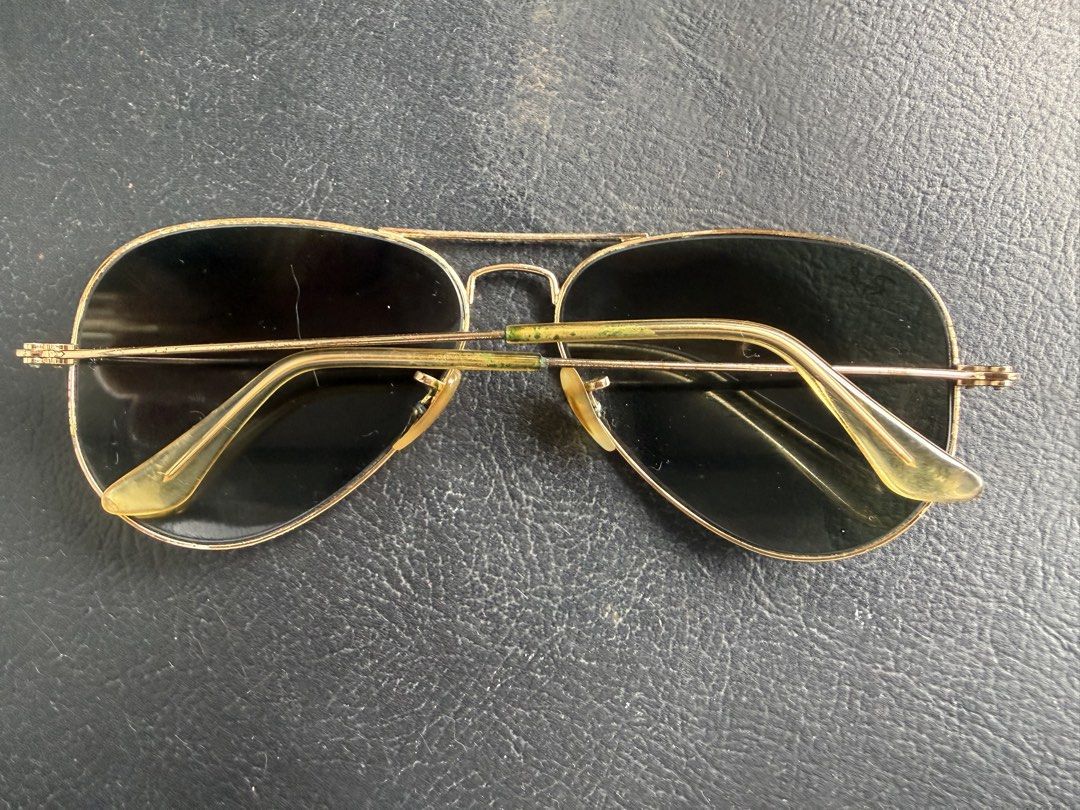 Ray-Ban Aviator Sunglasses Gold Frame RB3025 (Category: Sunglasses & Eyewear) located in Caloocan City. Submitted by mochibolala13 (Listing ID 1448278072, Image 2). Description: Classic Ray-Ban aviator sunglasses. Gold frame with dark lenses. Some minor scratches on the lenses, as expected for used sunglasses. The frame shows some signs of wear and slight discoloration on the arms. Includes original Ray-Ban case. Selling as is..