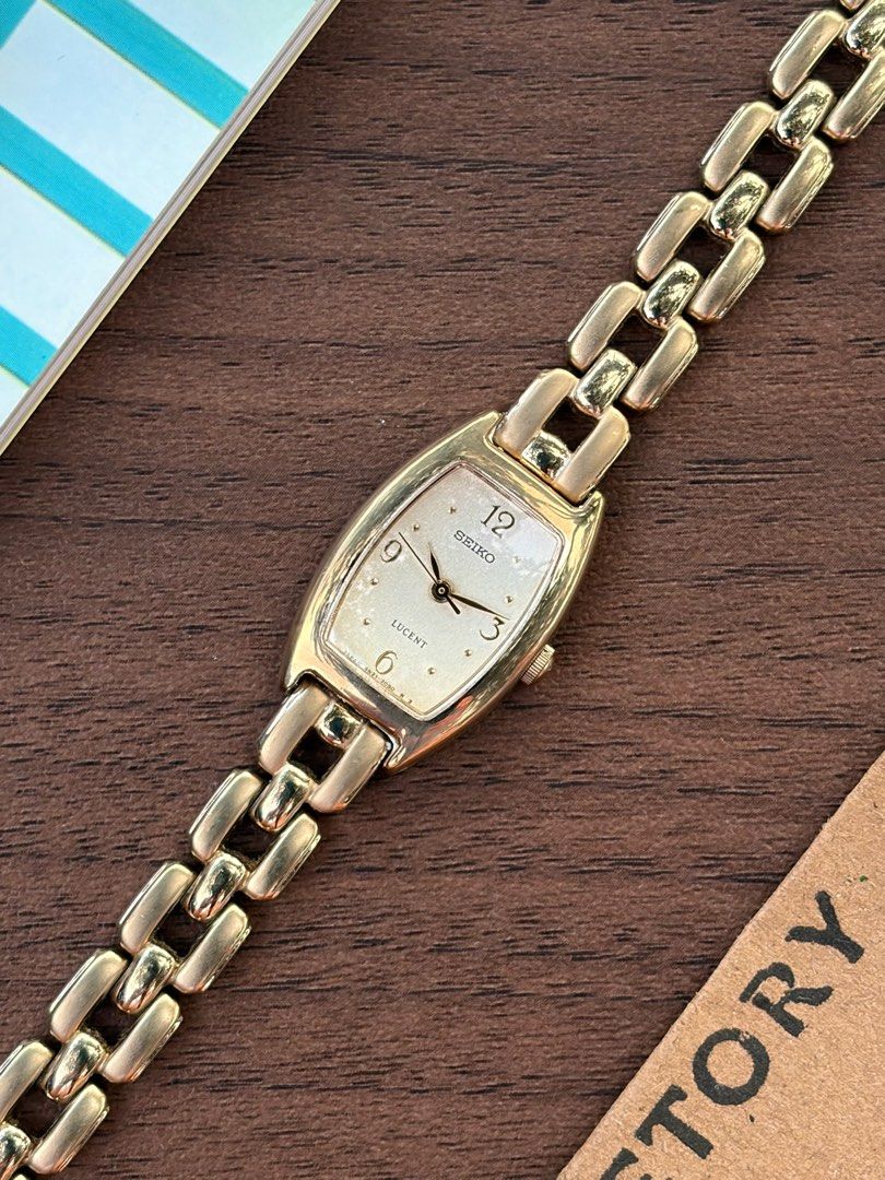 Seiko Lucent Gold Tonneau Dress Watch (Category: Watches) located in Petaling Jaya. Submitted by timetory (Listing ID 1448336467, Image 3). Description: Exuding a refined, jewelry-like charm, this vintage Seiko Lucent ladies’ dress watch frames a beautifully textured champagne dial within an elegant, gold-toned tonneau case. The clean and graceful dial configuration is detailed with subtle golden hour markers, delicate hands, and prominent numeri