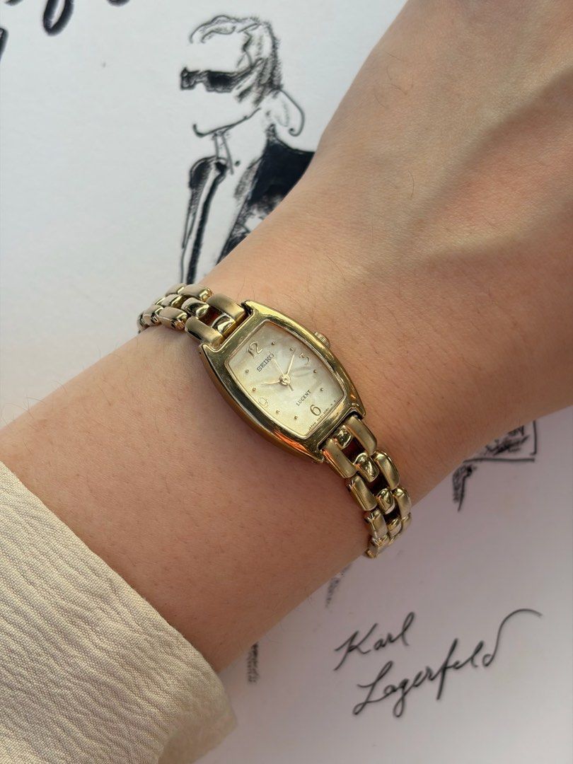Seiko Lucent Gold Tonneau Dress Watch (Category: Watches) located in Petaling Jaya. Submitted by timetory (Listing ID 1448336467, Image 2). Description: Exuding a refined, jewelry-like charm, this vintage Seiko Lucent ladies’ dress watch frames a beautifully textured champagne dial within an elegant, gold-toned tonneau case. The clean and graceful dial configuration is detailed with subtle golden hour markers, delicate hands, and prominent numeri