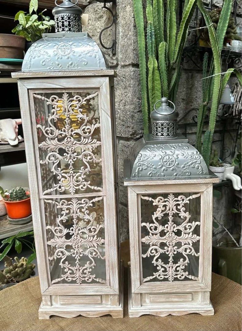 Set of 2 Vintage Style Decorative Lanterns (Category: Lighting) located in Cainta. Submitted by alvinroberto (Listing ID 1448366372, Image 2). Description: Sold as Set- 8000 -Metal, Wood and Glass Lantern w/ Polyresin Decor, -Very heavy, - Small-9.75”x9.75”x25” - Big-9.75”x9.75”x35.75”, MOD: lalamove.