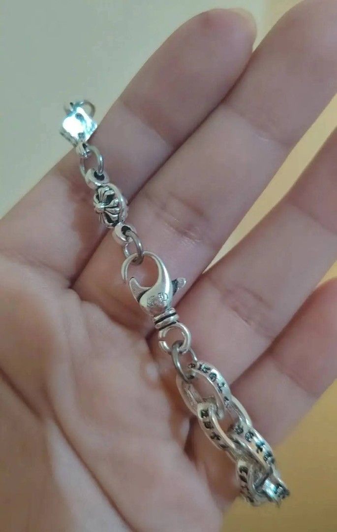 Chrome Heart bracelet (Category: Bracelets) located in Baguio. Submitted by thrifty_cool (Listing ID 1448477994, Image 2). Description: - Cool silver chain bracelet - Features dice and cross charms - Engraved text on links - Secure lobster clasp closure - Stamped 925, indicating sterling silver - Perfect accessory for any outfit.