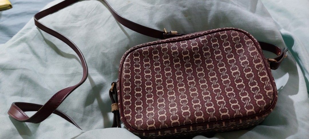 Tory Burch Monogram Crossbody Bag (Category: Luxury Bags & Wallets) located in Cainta. Submitted by veronica2277 (Listing ID 1448290989, Image 2). Description: - Authentic burgundy Tory Burch crossbody - Stylish burgundy and beige stripe detail down the middle - Signature gold Tory Burch logo - Genuine leather strap and trim - Secure zipper closure - Interior features Tory Burch logo - Ideal for everyday wear and errands - no major issues except 