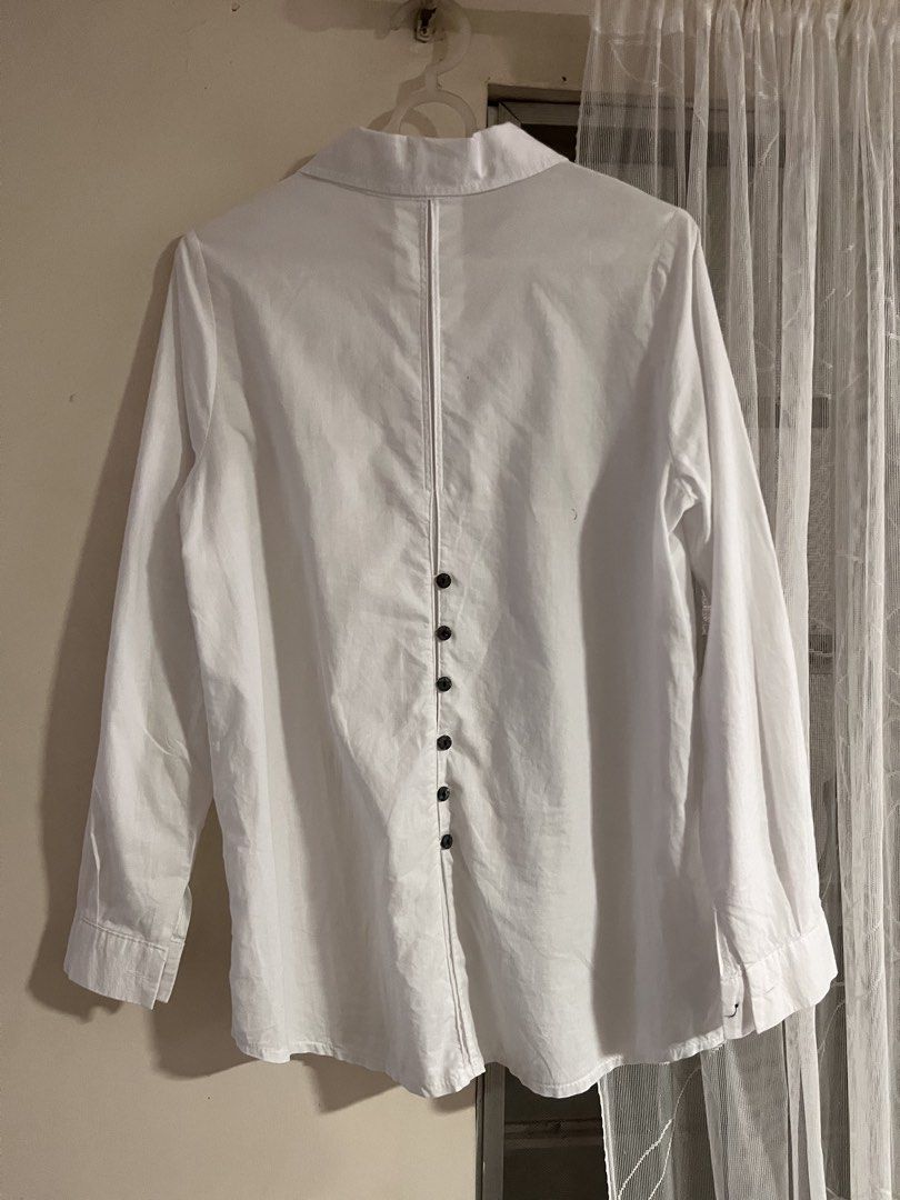 On Sale!!! White Button-Up Long Sleeves Polo with Black Buttons (Category: Shirts) located in Lipa City. Submitted by emscorner (Listing ID 1448315625, Image 2). Description: - Classic white button-up long sleeves - Size: S - Black button front closure - Unique button detail on the back - Roll-up sleeve tabs included - Perfect for both casual and formal occasions.