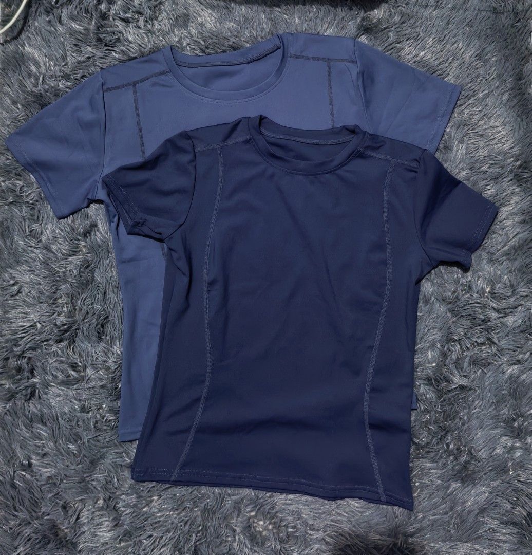 Athletic T-shirts Navy Blue & Dark Blue (Category: Activewear) located in Manila. Submitted by fiopicks (Listing ID 1448573593, Image 1). Description: - Set of two short-sleeved t-shirts -Size: Medium - Colors: Navy blue and darker blue - Style: Crew neck, athletic/performance wear - Features: Visible side stitching - Navy blue shirt length: Approximately 27 inches For reference: Height - 5'2 (158.5cm) Bust- 31in Waist- 28in.