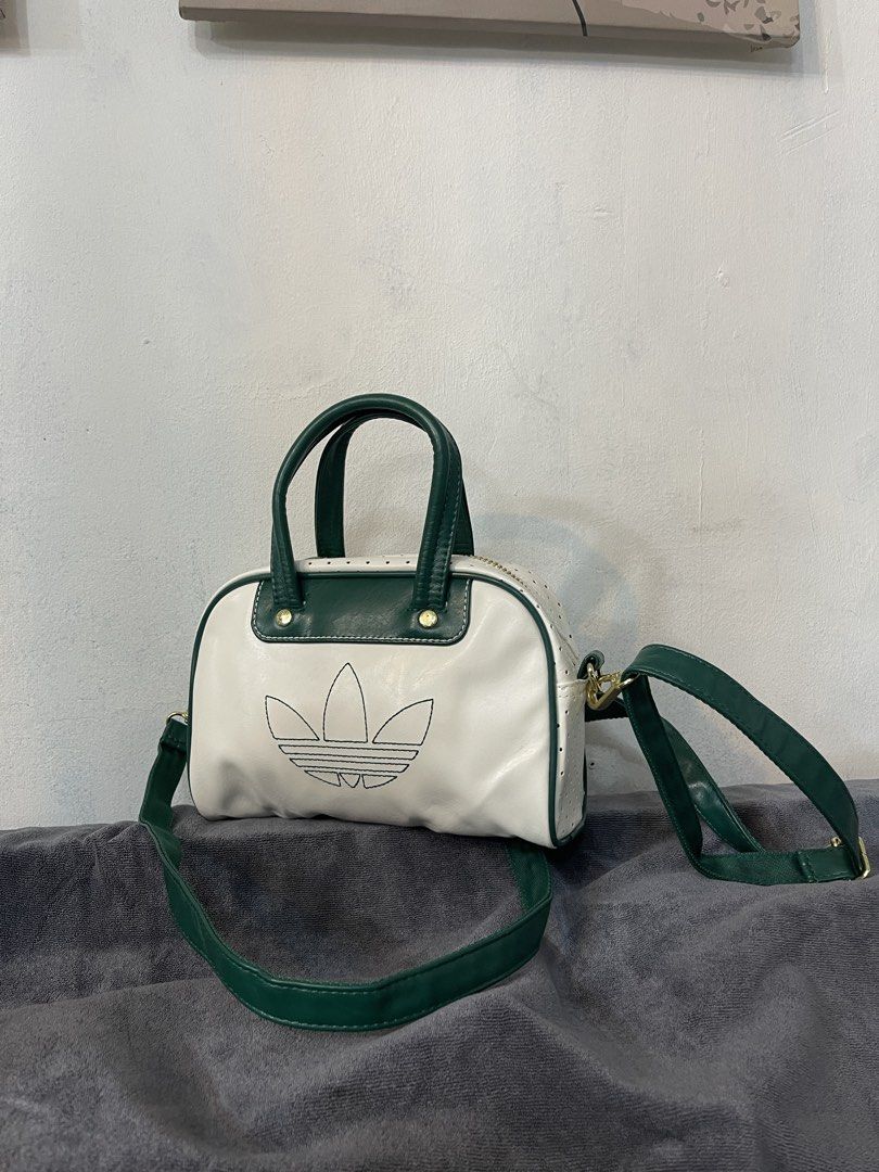 Adidas Mini Duffle Bag White Green (Category: Luxury Bags & Wallets) located in Lupao. Submitted by jennylynda42204 (Listing ID 1448630079, Image 2). Description: - Cute mini duffle bag from Adidas - Color: White with green trim and handles - Classic Adidas trefoil logo on the front - Includes a detachable shoulder strap - Gold zipper and hardware - Small size, ideal for carrying essentials.