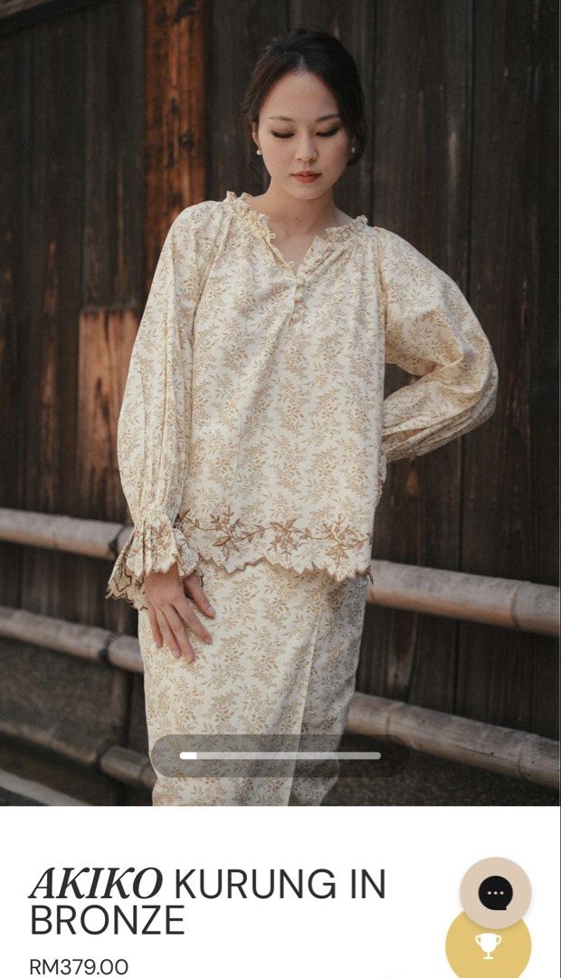 Akiko Kurung in Bronze Floral Set (Category: Baju Kurung & sets) located in Putrajaya. Submitted by aestheticshopbywa (Listing ID 1448497981, Image 1). Description: - Akiko Kurung set in elegant bronze. - Features a delicate all-over floral print. - Top: Ruffled neckline and stylish balloon sleeves with ruffled cuffs. - Skirt: Matching design with a beautifully embroidered hem. - Perfect for traditional occasions. - New with tag and box -L size.