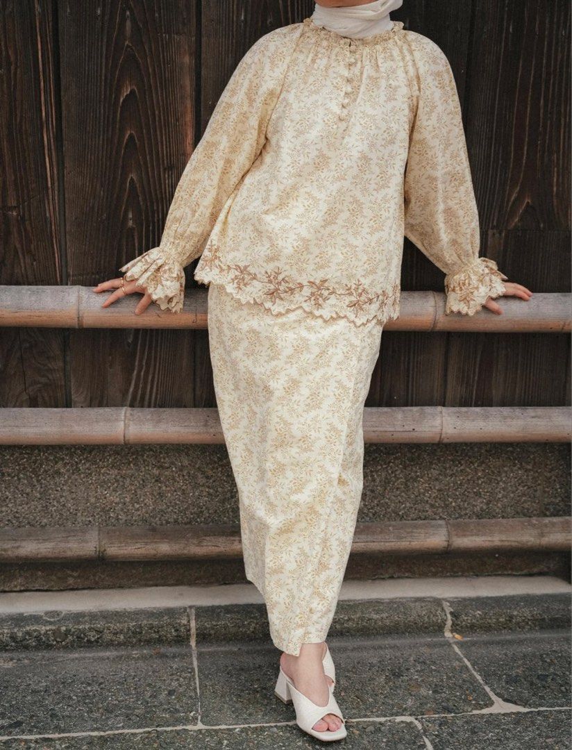 Akiko Kurung in Bronze Floral Set (Category: Baju Kurung & sets) located in Putrajaya. Submitted by aestheticshopbywa (Listing ID 1448497981, Image 3). Description: - Akiko Kurung set in elegant bronze. - Features a delicate all-over floral print. - Top: Ruffled neckline and stylish balloon sleeves with ruffled cuffs. - Skirt: Matching design with a beautifully embroidered hem. - Perfect for traditional occasions. - New with tag and box -L size.