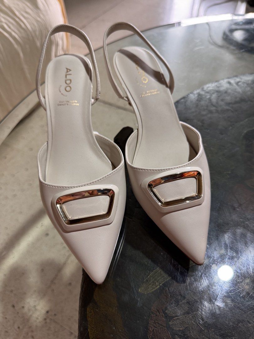 ALDO White Slingback Heels with Gold Buckle (Category: Heels) located in Marikina City. Submitted by 1stuffshop (Listing ID 1448485468, Image 1). Description: - Brand: ALDO - Style: White slingback heels - Features: Pointed toe, gold buckle detail, adjustable ankle strap - Heel Height: Moderate - Condition: Soles show some signs of wear - Versatility: Great for dressing up or down.