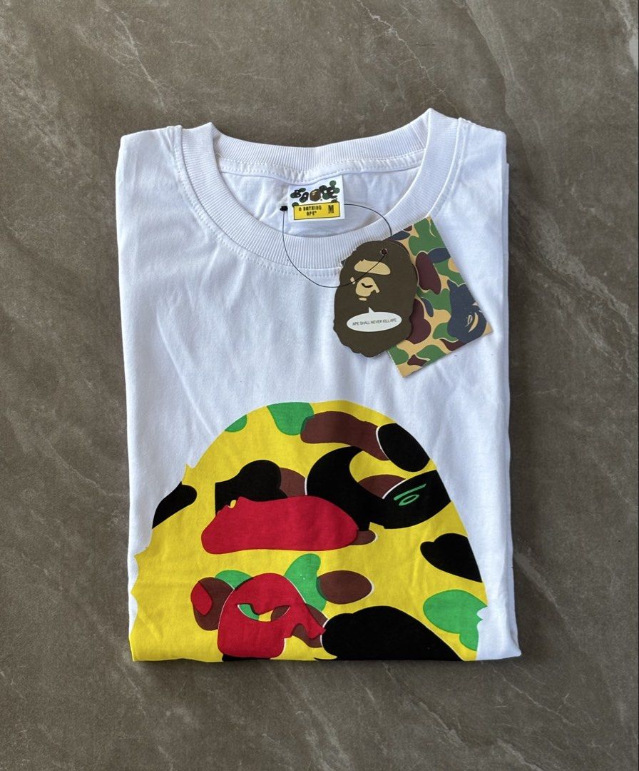 BAPE x Undefeated Camo Ape Head Tee White (Category: Tshirts & Polo Shirts ) located in Zaragoza. Submitted by starzoneph (Listing ID 1448547122, Image 3). Description: Undefeated Camo Bathing Ape Size: Medium •Width: 19 • Length: 27 • Available Sizes XL • Good condition • Color rate: 10/10.