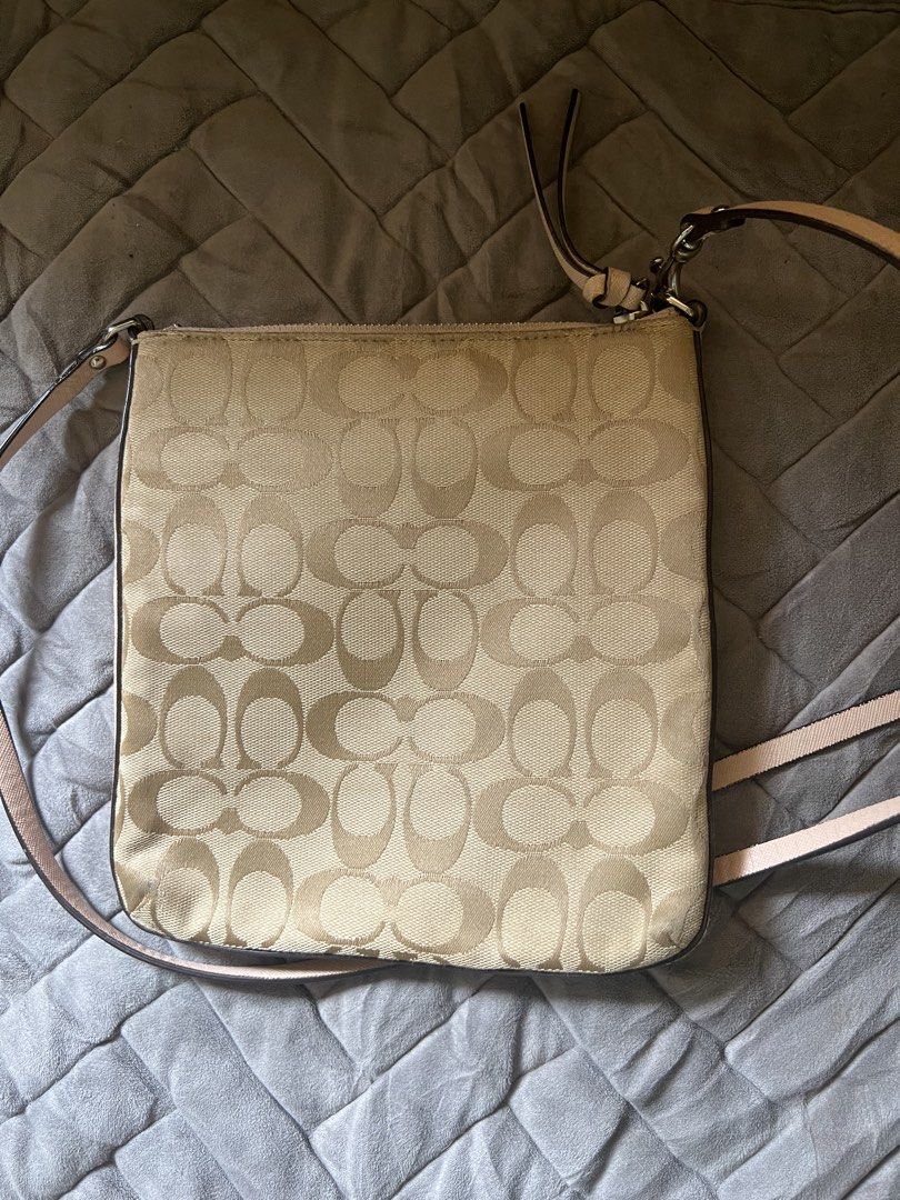 Coach Signature Monogram Crossbody Bag (Category: Luxury Bags & Wallets) located in Saravia. Submitted by clynlyn (Listing ID 1448542953, Image 2). Description: - Authentic Coach crossbody bag - Signature monogram canvas with light pink leather trim and strap - Secure zipper closure - Adjustable strap for comfortable wear - Interior lined in light pink satin-like material - Minor marks present inside the bag.