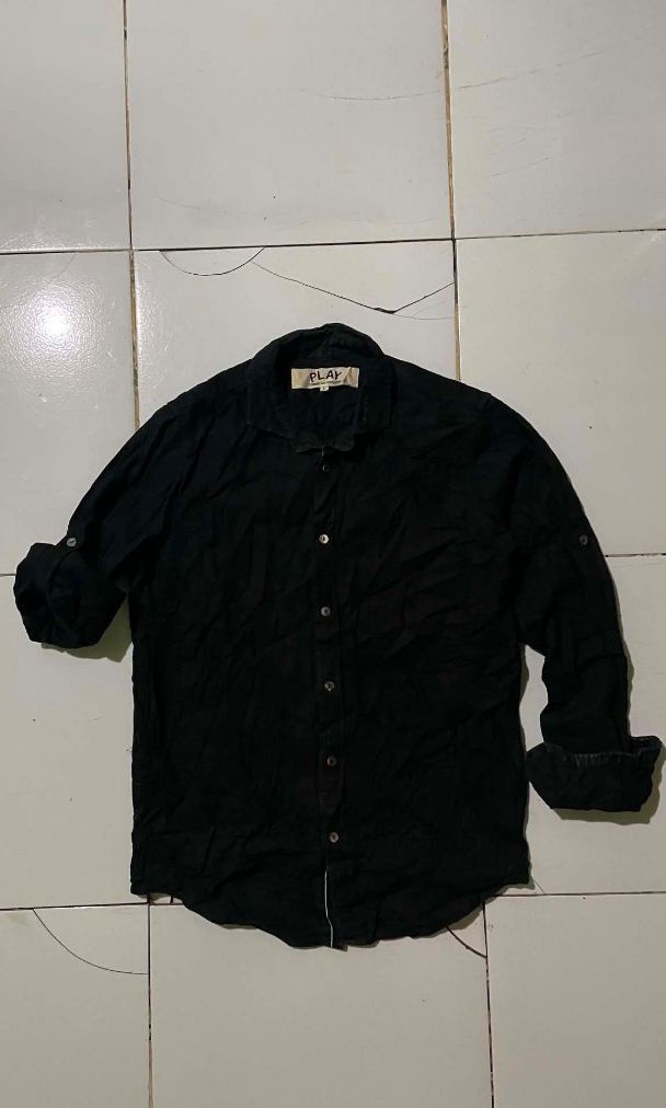 Comme des Garçons PLAY Black Button-Up Shirt (Category: Shirts) located in Barotac Nuevo. Submitted by gray101 (Listing ID 1441106043, Image 1). Description: - Brand: Comme des Garçons PLAY - Color: Black - Size: L - Origin: Made in Japan - Style: Classic collared button-up shirt - Versatile: Suitable for casual and semi-formal occasions.