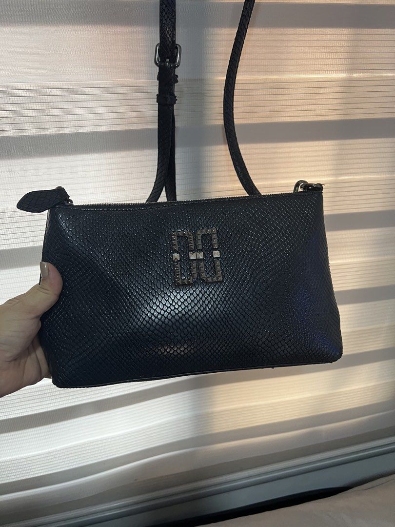 DAKS Black Snakeskin Crossbody Bag (Category: Cross-body Bags) located in Las Pinas. Submitted by maple0305 (Listing ID 1448561128, Image 1). Description: - Stylish black crossbody bag - Unique snakeskin texture - Prominent DAKS logo on the front - Interior zip pocket for essentials - Signature DAKS logo pattern lining - Adjustable strap for comfortable wear - Ideal for everyday use.