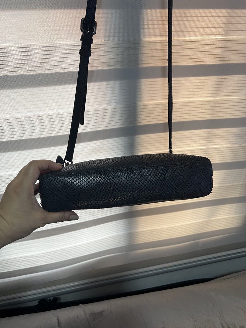 DAKS Black Snakeskin Crossbody Bag (Category: Cross-body Bags) located in Las Pinas. Submitted by maple0305 (Listing ID 1448561128, Image 2). Description: - Stylish black crossbody bag - Unique snakeskin texture - Prominent DAKS logo on the front - Interior zip pocket for essentials - Signature DAKS logo pattern lining - Adjustable strap for comfortable wear - Ideal for everyday use.