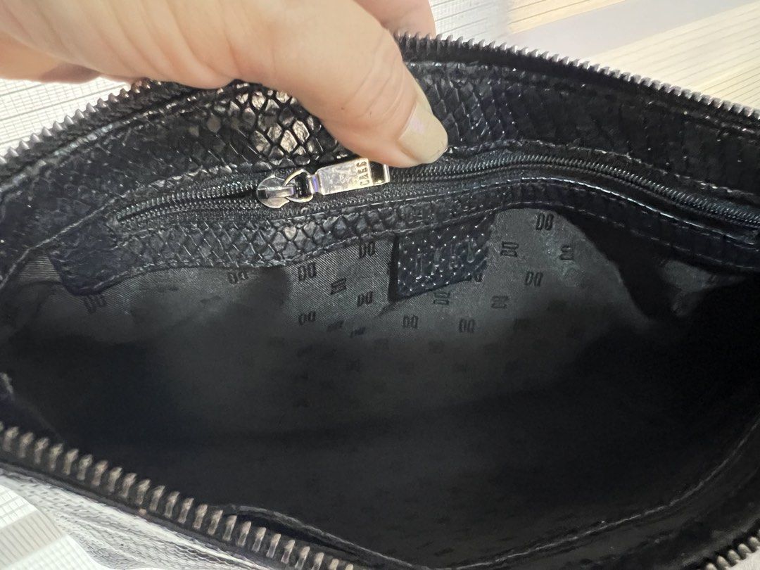 DAKS Black Snakeskin Crossbody Bag (Category: Cross-body Bags) located in Las Pinas. Submitted by maple0305 (Listing ID 1448561128, Image 3). Description: - Stylish black crossbody bag - Unique snakeskin texture - Prominent DAKS logo on the front - Interior zip pocket for essentials - Signature DAKS logo pattern lining - Adjustable strap for comfortable wear - Ideal for everyday use.