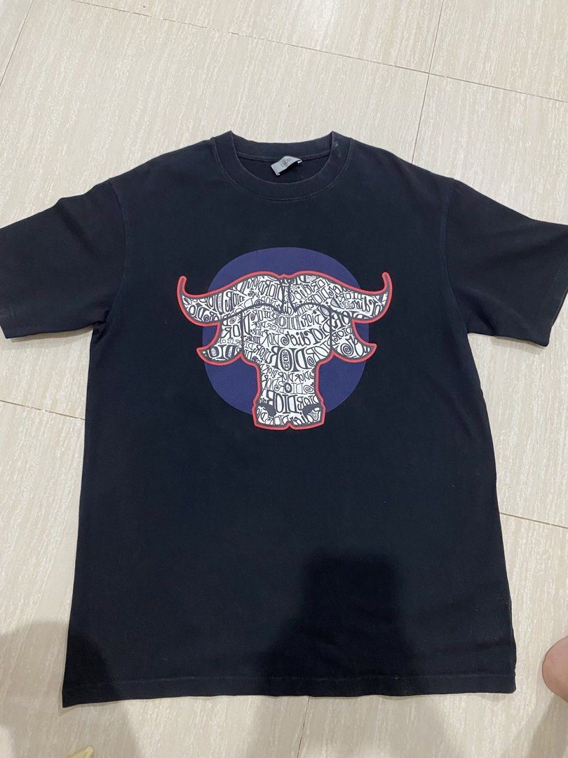 Dior x Stussy T-shirt (Category: Tshirts & Polo Shirts ) located in Luisiana. Submitted by matchacoach (Listing ID 1448389929, Image 3). Description: Black Dior t-shirt. Features a graphic print of a bull's head made of text. Crew neck, short sleeves. Good for casual wear. Check photos for details. ps. The neck area has a small white spot, but it can still be cleaned since it’s just dirt. Message me for more details! Price is negotiable.