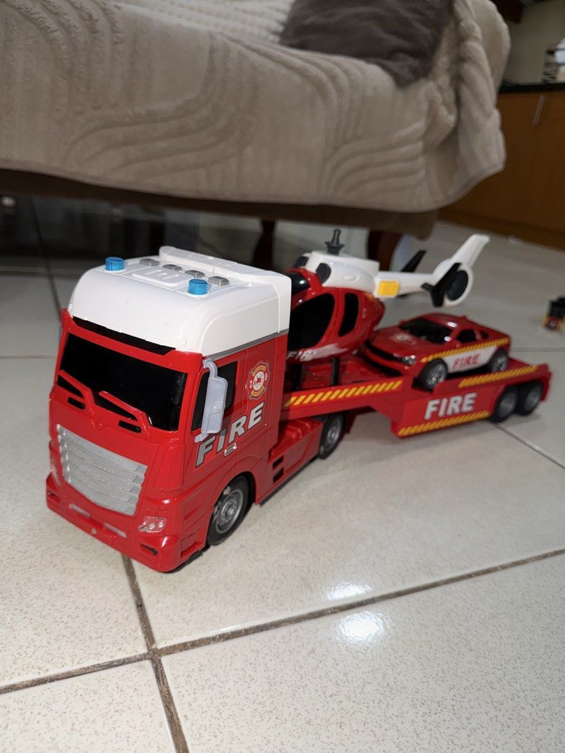Fire Truck Set (Category: Kids Toys) located in Antipolo. Submitted by kzees (Listing ID 1448490607, Image 2). Description: - Red toy truck with detachable trailer - Includes a red toy helicopter and a red toy sports car - All vehicles feature 'FIRE' branding - Trailer detaches for versatile play - Ideal for imaginative play and young fans of emergency vehicles What you see is what you get..