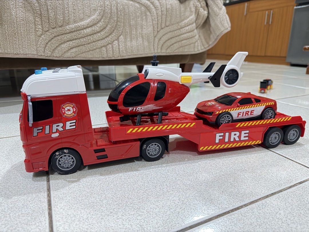 Fire Truck Set (Category: Kids Toys) located in Antipolo. Submitted by kzees (Listing ID 1448490607, Image 3). Description: - Red toy truck with detachable trailer - Includes a red toy helicopter and a red toy sports car - All vehicles feature 'FIRE' branding - Trailer detaches for versatile play - Ideal for imaginative play and young fans of emergency vehicles What you see is what you get..