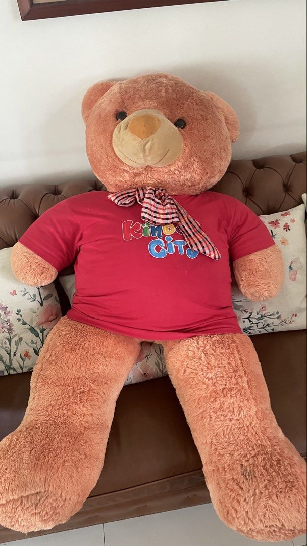 Giant/BIG Teddy Bear (Category: Plushies & Soft Toys) located in Taguig. Submitted by kobbey (Listing ID 1448524608, Image 1). Description: - Super big teddy bear - Light brown color - Wearing a red t-shirt with 'King City' print - Soft and cuddly - Ideal for gifts or room decoration - Ready for hugs!.