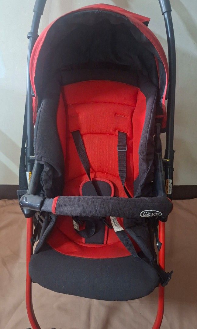 GRACO LITEWEIGHT RED and Black Stroller (Category: Strollers) located in Quezon City. Submitted by declutterseoul (Listing ID 1448516154, Image 2). Description: Selling low coz I need to declutter it asap. Needs deep cleaning. Original, mall bought namin. Orange and black stroller. Has a canopy and harness. Seems sturdy. Ready for a new home. Great for getting around..